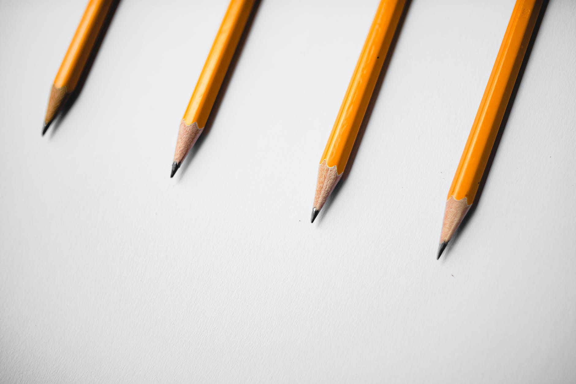 Four sharpened pencils against a white background. 