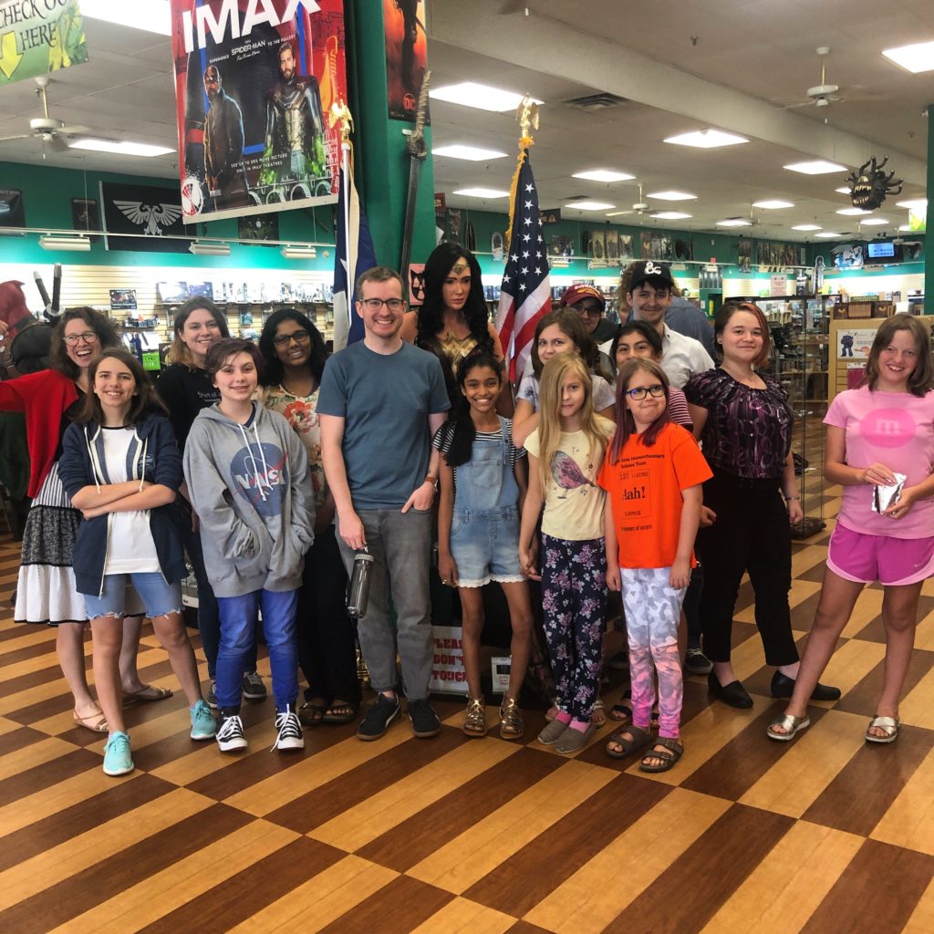 Image shows a class of ABC students and their volunteer standing together in a bookstore.