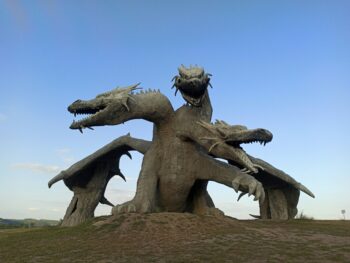 An outdoor stone statue of a three-headed dragon